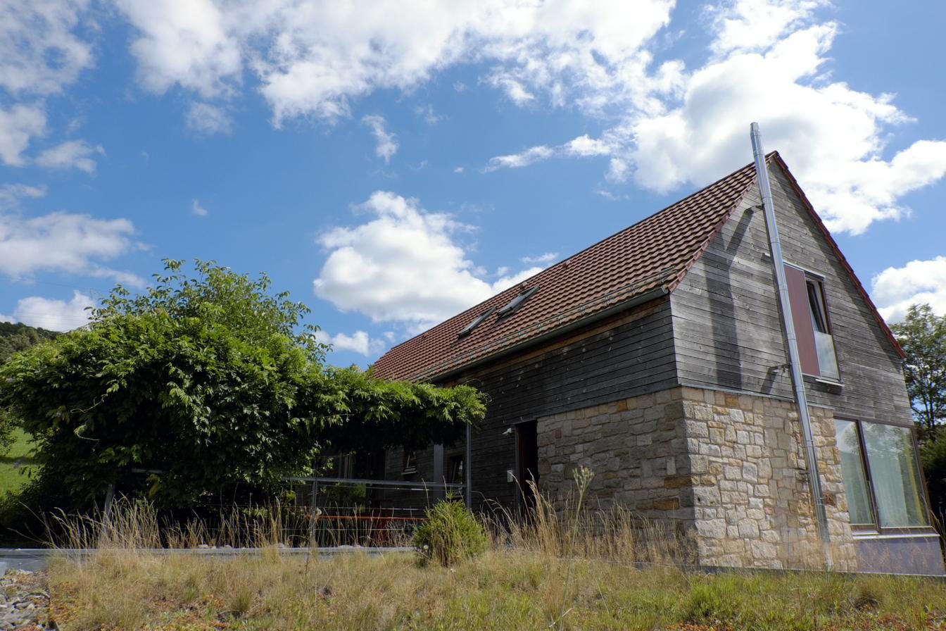 Ferienhaus Reich in Ehrenberg (Rhön) mit Holz- und Natursteinfassade unter blauem Himmel